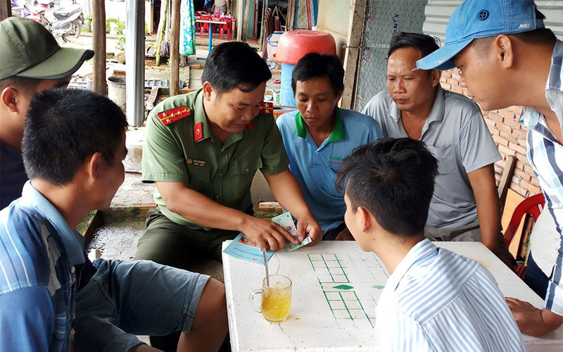Cán bộ Phòng An ninh kinh tế (Công an tỉnh Hậu Giang) hướng dẫn người dân trên địa bàn thị xã Long Mỹ cách nhận biết tiền giả. Ảnh: THANH DANH
