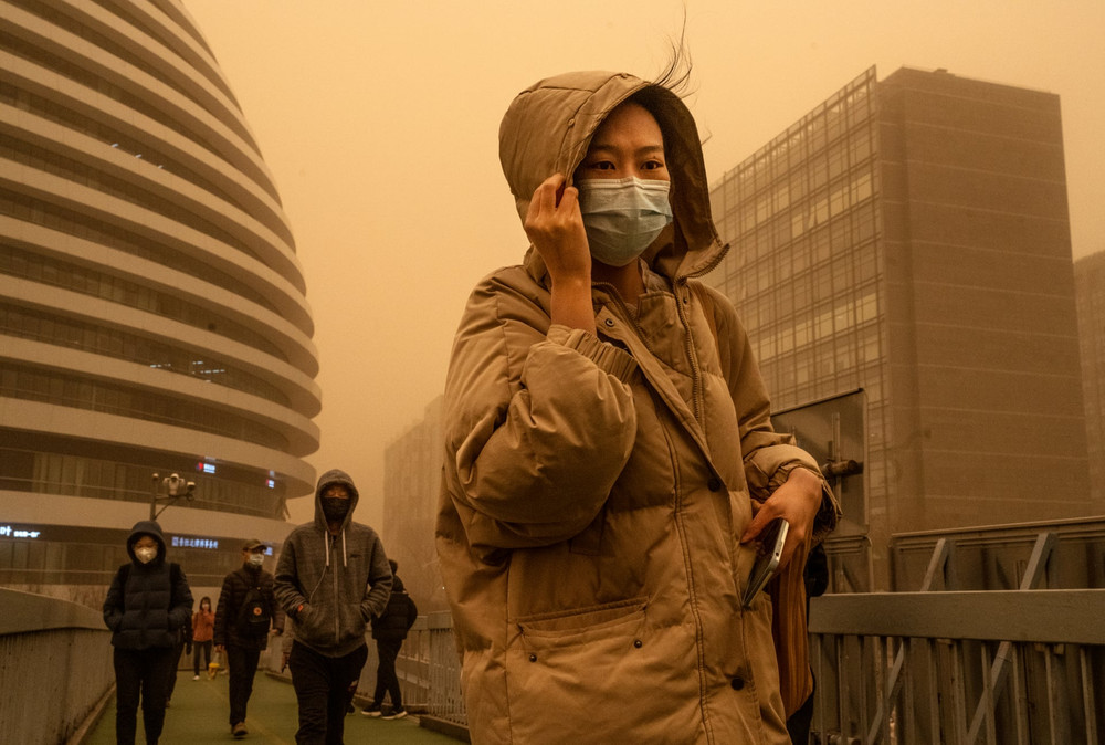 Người dân Bắc Kinh di chuyển trong cơn bão cát và gió lớn. (Ảnh: Getty Imges) Climate crisis -0