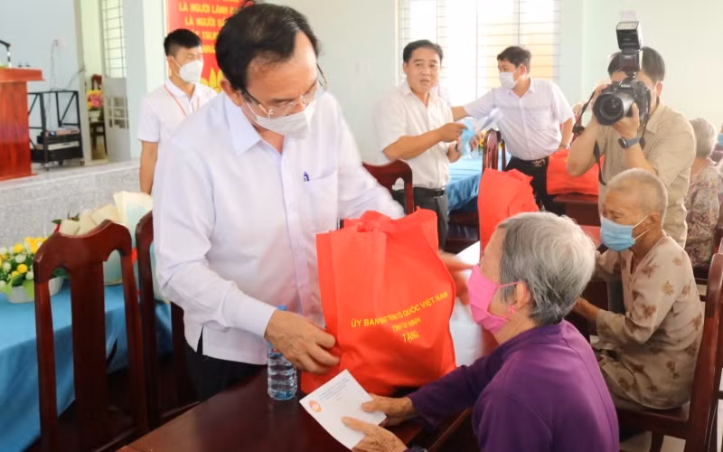 Đồng chí Nguyễn Văn Nên, Ủy viên Bộ Chính trị, Bí thư Thành ủy TP Hồ Chí Minh (bên trái) trao quà tặng người dân.