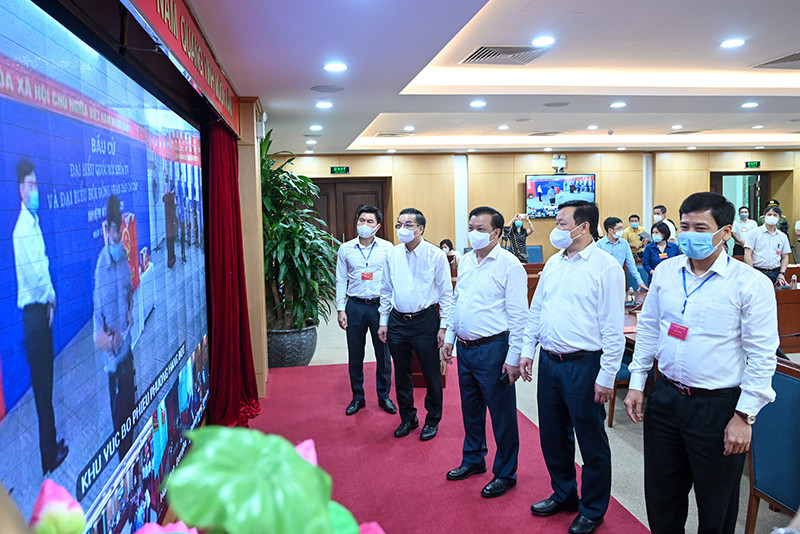 Bí thư Thành ủy Đinh Tiến Dũng cùng các đồng chí lãnh đạo thành phố theo dõi hoạt động bầu cử bằng hình thức trực tuyến tại Trung tâm Ban Chỉ đạo bầu cử quận Đống Đa. Ảnh: DUY LINH Cử tri Hà Nội thực hiện nghiêm công tác phòng dịch trong ngày bầu cử -0