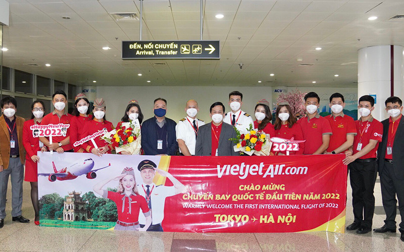 Lãnh đạo Cục Hàng không, Cảng hàng không và Vietjet chào đón những vị khách quốc tế đầu tiên đến Nội Bài. (Ảnh: Hãng hàng không Vietjet cung cấp) Vietjet đón chuyến bay quốc tế đầu tiên trong ngày đầu năm -0