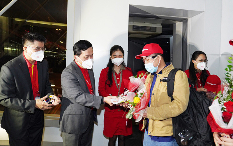 Giám đốc Điều hành Vietjet Đinh Việt Phương tặng hoa và lì xì may mắn cho hành khách trên chuyến bay đầu tiên của năm mới. (Ảnh: Hãng hàng không Vietjet cung cấp) Vietjet đón chuyến bay quốc tế đầu tiên trong ngày đầu năm -0