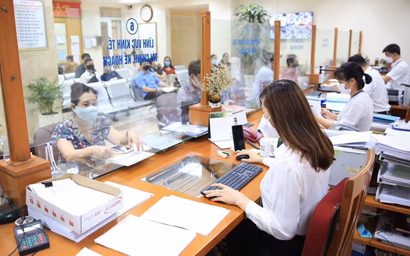 Giải quyết thủ tục hành chính cho người dân tại bộ phận “một cửa” UBND quận Hoàn Kiếm. (Ảnh: NGUYỄN QUANG)