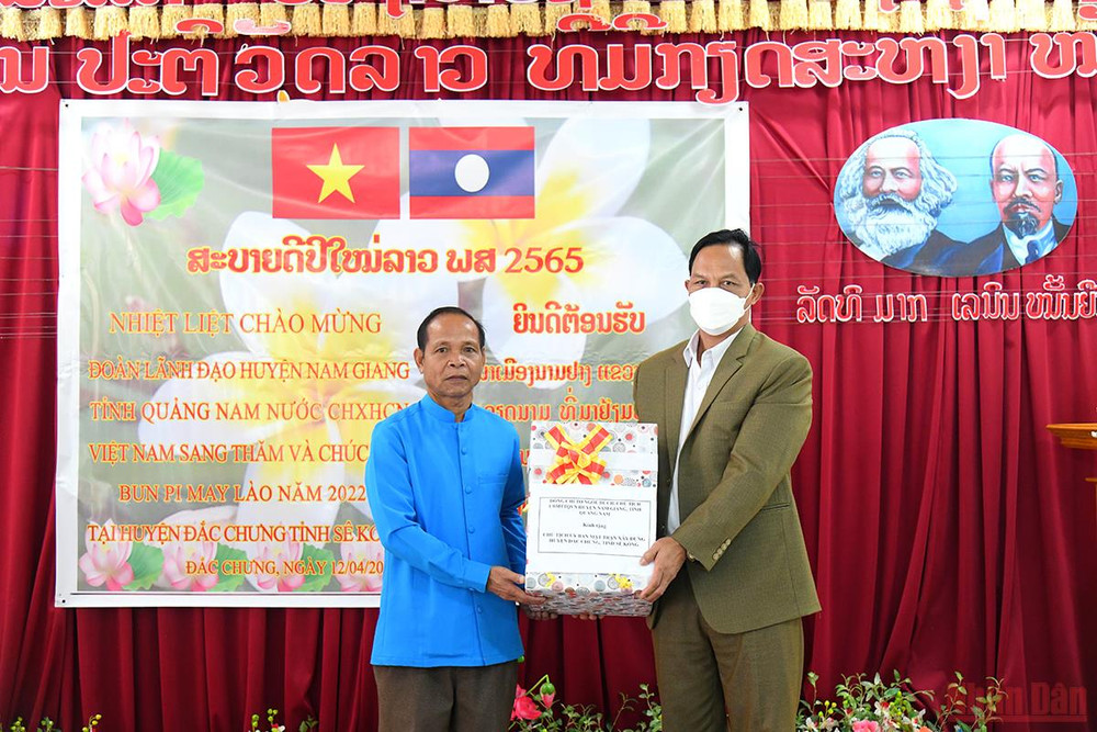 Đồng chí Tơ Ngôl Dứch, Chủ tịch Ủy ban Mặt trận Tổ quốc huyện Nam Giang tặng quà, chúc Tết Chủ tịch Mặt trận xây dựng huyện Đắc Chưng. (Ảnh: THÀNH ĐẠT) Quan hệ hữu nghị đặc biệt Việt - Lào: Tết của bạn là Tết của mình -0