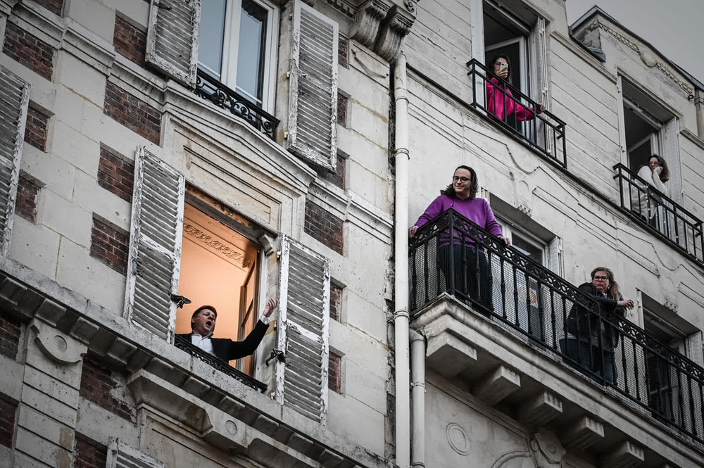 Bên cửa sổ của căn hộ tại thủ đô Paris, nghệ sĩ opera Stephane Senechal hát cho những người hàng xóm nghe trong ngày thứ 10 Pháp áp đặt lệnh phong tỏa. (Ảnh: Getty Images) 1 -0