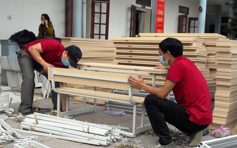 Người lao động lắp ráp bàn ghế tại Trường Tiểu học Điện Biên 2, sáng 16/1. Thành phố Thanh Hóa điều trị F0 tại nhà -0