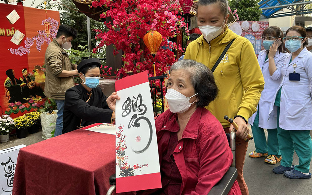 Một bệnh nhân xin chữ “Bình an” tại đường hoa Chợ Rẫy. Rực rỡ đường hoa Chợ Rẫy -0