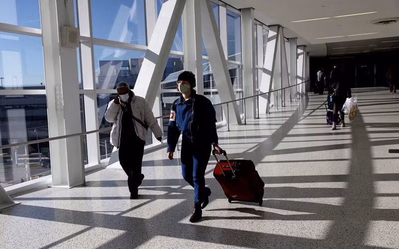 Hành khách đeo khẩu trang di chuyển tại sân bay quốc tế JFK ở New York, Mỹ, ngày 16/11/2021. (Ảnh: Reuters)