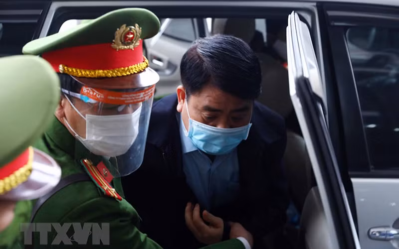 Bị cáo Nguyễn Đức Chung (cựu Chủ tịch Ủy ban Nhân dân thành phố Hà Nội) được lực lượng chức năng dẫn giải đến phiên tòa. (Ảnh: TTXVN)