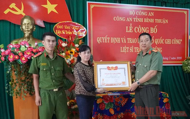 Gia đình Liệt sĩ Trần Văn Dũng (vợ và con trai bên trái) nhận Bằng “Tổ quốc ghi công”.