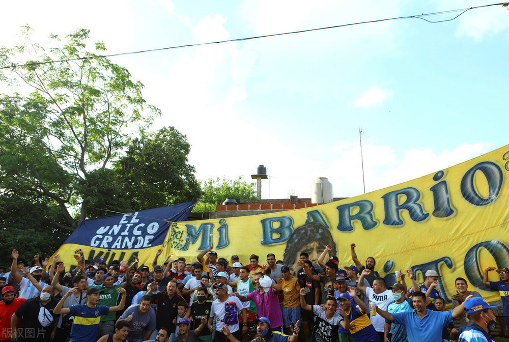 Những người hàng xóm và fan hâm mộ của Maradona tập trung trước biểu ngữ "Khu phố của tôi" trong khu “ổ chuột” Villa Fiorito, nơi Maradona từng trải qua thời thơ ấu của mình. (Ảnh: Reuters/Matias Baglietto) Người hâm mộ khắp thế giới tiếc thương Maradona -2