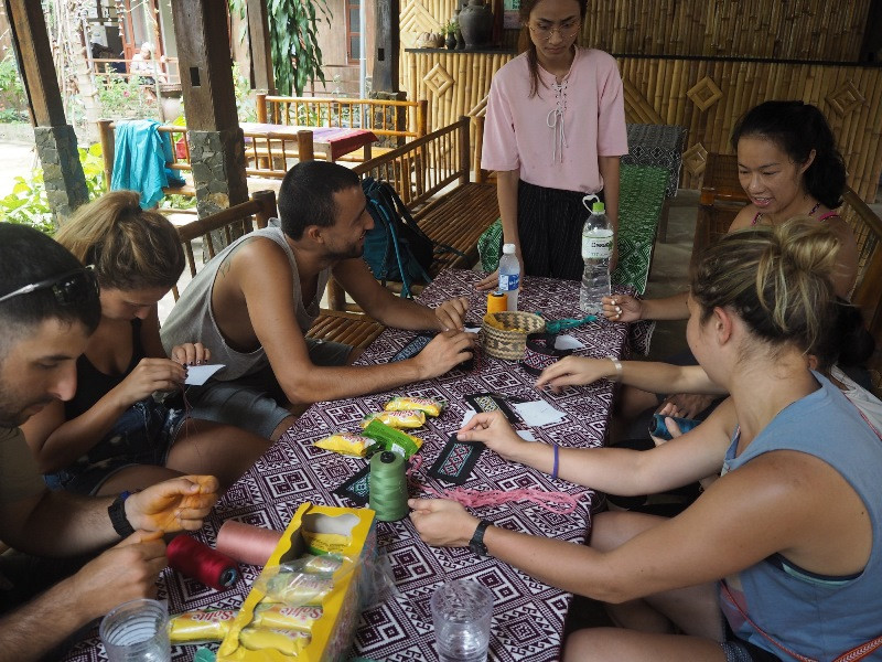 Du khách nước ngoài tham gia trải nghiệm tự dệt, nhuộm màu tự nhiên và thêu khăn tay trong các chương trình thực tế của EWA, nhằm tìm hiểu về nghề dệt truyền thống của Việt Nam. Hỗ trợ phụ nữ dân tộc thiểu số tại các làng nghề dệt truyền thống -0