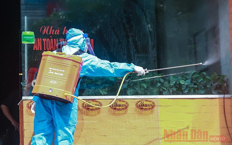  Lực lượng chức chức năng quận Cầu Giấy đã tiến hành phong tỏa, phun khử trùng bên trong và chung quanh quán pizza trên phố Trần Thái Tông. (Ảnh: HÀ NAM)