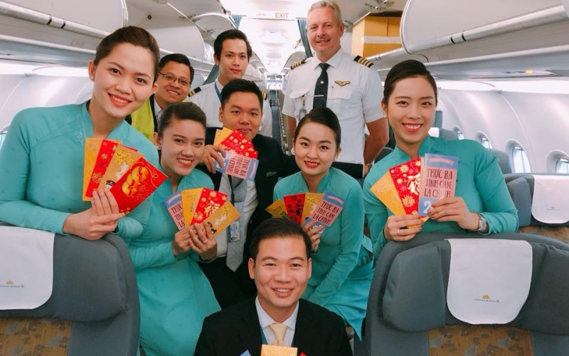Tiếp viên trưởng, giáo viên Lưu Công Minh (áo đen) cùng phi hành đoàn trong chuyến bay xuyên giao thừa năm 2018. (Ảnh: Hãng hàng không Vietnam Airlines cung cấp) Xuân về dưới cánh bay -0