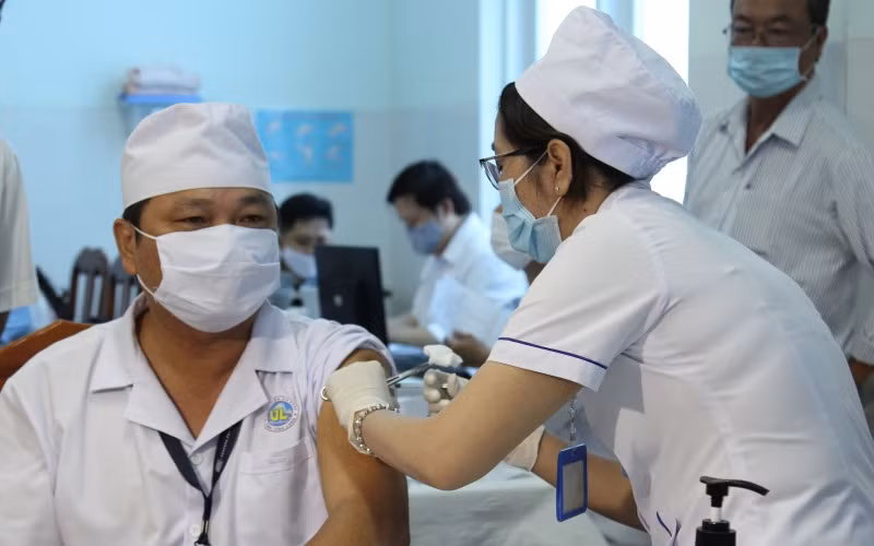 Điều dưỡng Nguyễn Văn Võ, Khoa kiểm soát nhiễm khuẩn thuộc đội phản ánh nhanh phòng, chống Covid-19 tại Bệnh viện đa khoa tỉnh Vĩnh Long được tiêm mũi đầu tiên.