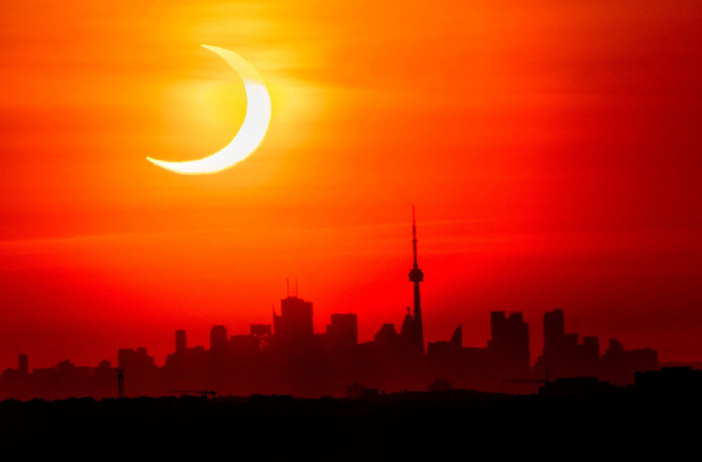 Nhật thực ngày 10-5 trên đường chân trời ở Toronto, Canada. Ảnh: AP. Những vòng lửa tuyệt đẹp trong nhật thực hình khuyên -0