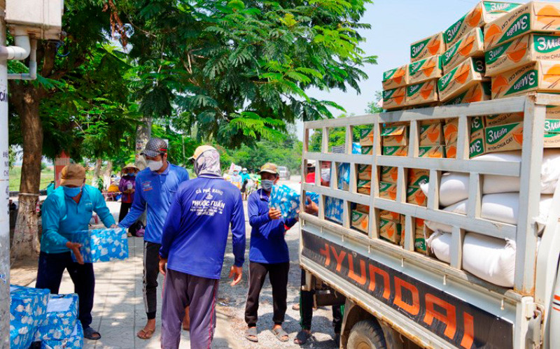 Nhân công đang bốc gạo sang xe của Tổng Hội Việt kiều Campuchia. (Ảnh: Phú Quý)