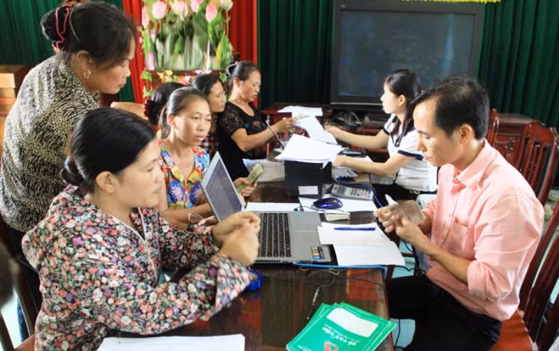 Cán bộ Ngân hàng Chính sách xã hội TP Hà Nội giúp người dân làm thủ tục vay vốn.