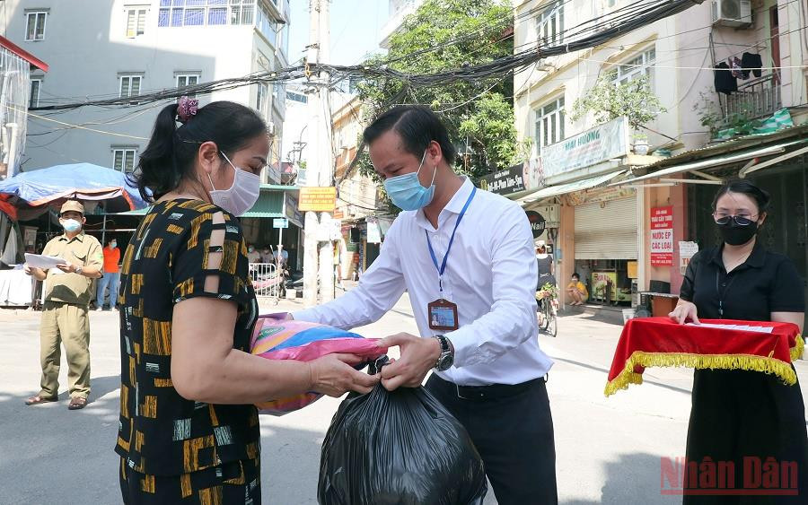 UBND phường Dịch Vọng Hậu (Cầu Giấy) trao tiền hỗ trợ và nhu yếu phẩm cho người dân có hoàn cảnh khó khăn. (Ảnh: DUY LINH) 10 sự kiện tiêu biểu của Thủ đô Hà Nội năm 2021 -0