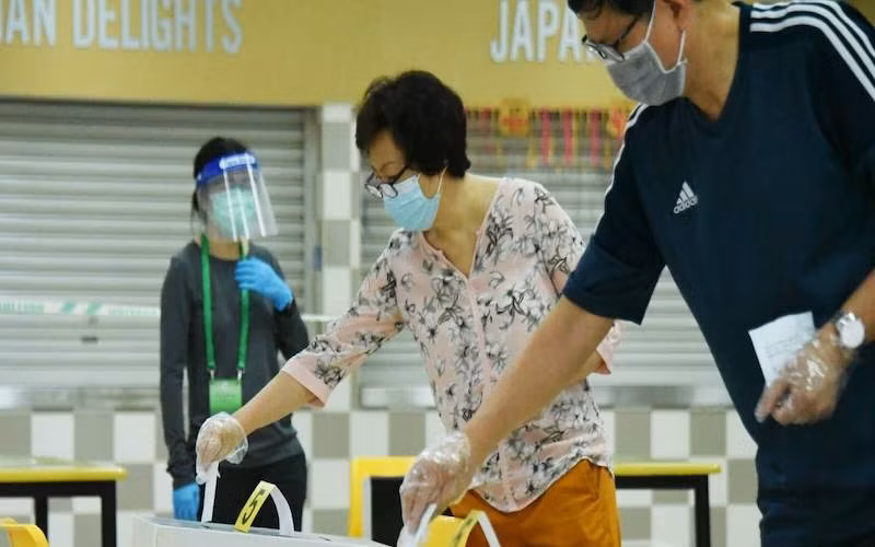 Cử tri Singapore đeo khẩu trang và găng tay bỏ phiếu tại Trường trung học Chung Cheng, ngày 10-7-2020. (Ảnh: Channel News Asia)