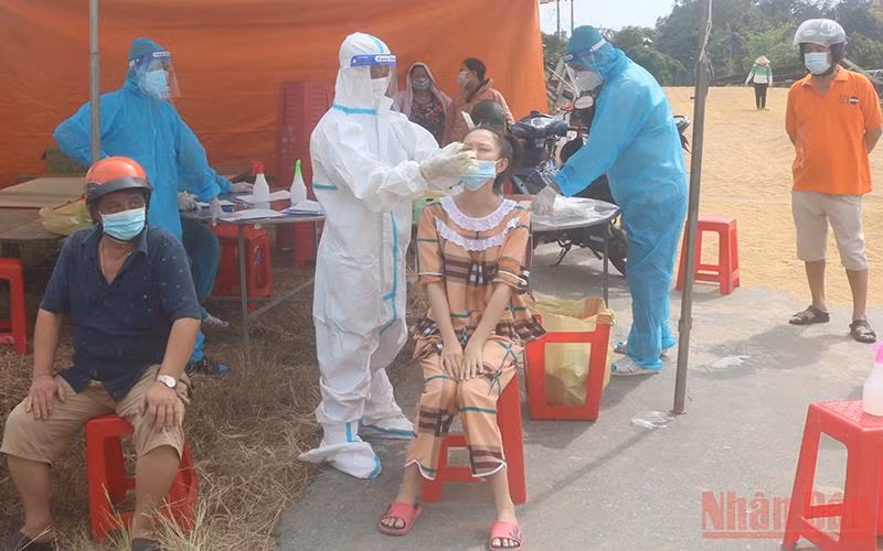 Nhân viên y tế xét nghiệm nhanh SARS-CoV-2 cho người dân. 