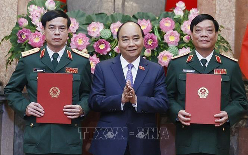 Chủ tịch nước Nguyễn Xuân Phúc, Thống lĩnh các lực lượng vũ trang nhân dân, Chủ tịch Hội đồng Quốc phòng và An ninh trao Quyết định thăng quân hàm từ Trung tướng lên Thượng tướng đối với đồng chí Ngô Minh Tiến và Lương Đình Hồng. (Ảnh: TTXVN)