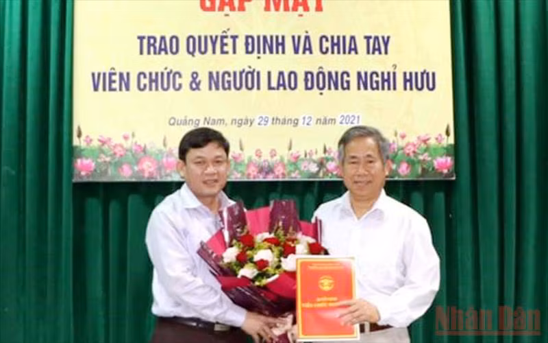 Tiến sĩ Trần Tấn Vịnh (Trường Đại học Quảng Nam, người đứng bên phải) nhận quyết định nghỉ hưu trước tuổi trong đợt 1 năm 2022.
