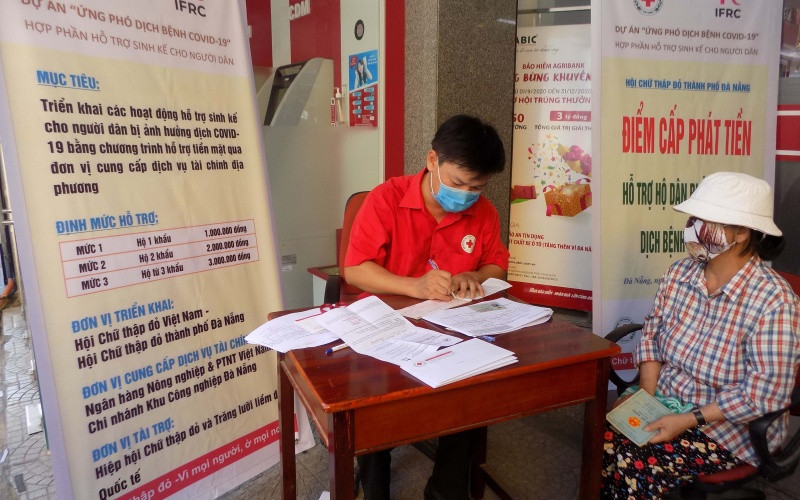 Người dân nhận tiền hỗ trợ.