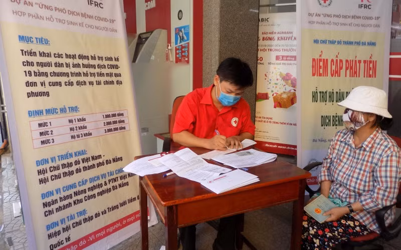 Người dân nhận tiền hỗ trợ.