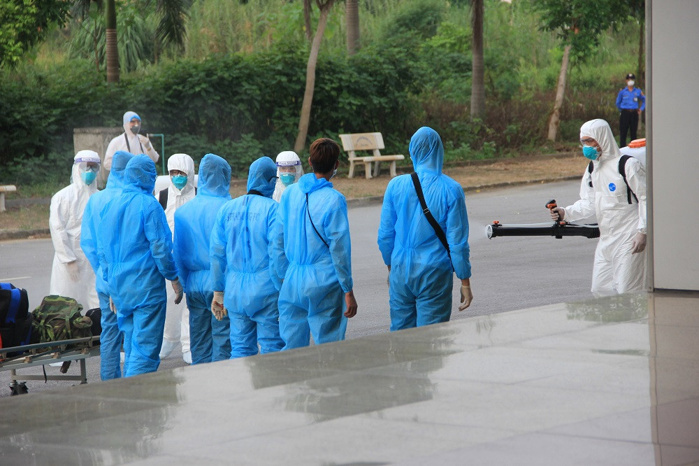 Các công dân khử khuẩn trước khi vào bệnh viện. Đưa 219 công dân Việt Nam từ Guinea Xích đạo về nước an toàn -0