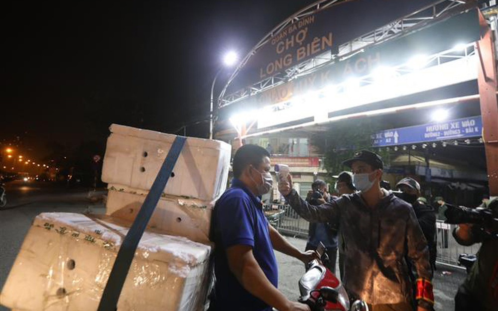 Đo thân nhiệt cho người ra vào chợ. (Ảnh: VTV) Chợ Long Biên hoạt động trở lại từ 0 giờ ngày 21/10 -4