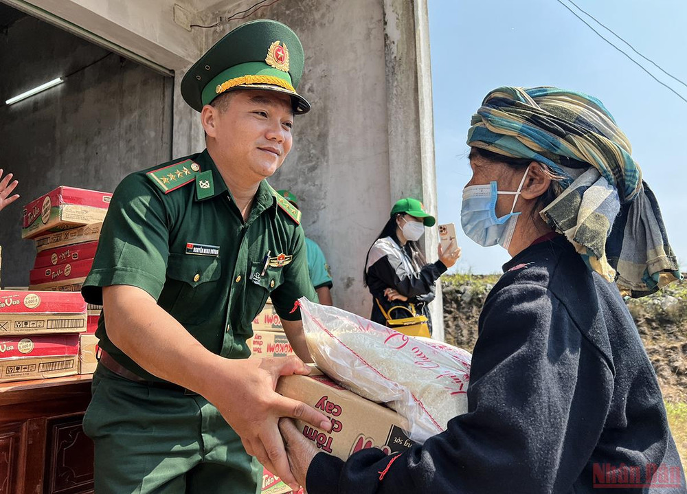 Cán bộ chiến sĩ Đồn Biên phòng Nam Giang trao nhu yếu phẩm cho nhân dân Lào. (Ảnh: THÀNH ĐẠT) Quan hệ hữu nghị đặc biệt Việt - Lào: Tết của bạn là Tết của mình -0