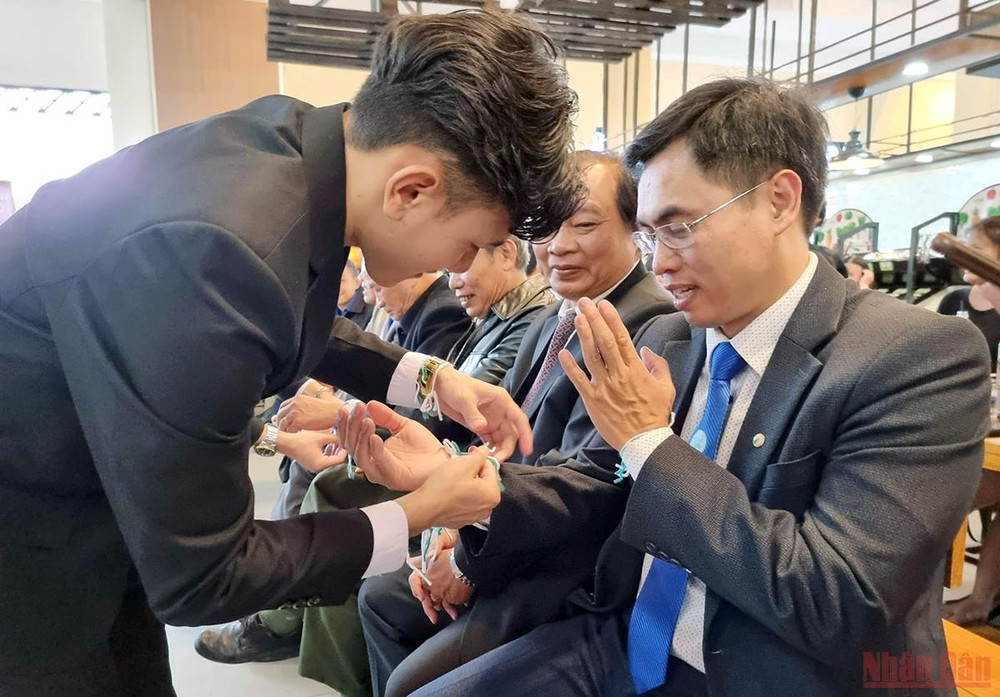 Các sinh viên Lào thực hiện lễ buộc chỉ cổ tay cho những người tham dự. Sinh viên Lào tại Trường Đại học Đà Lạt được các gia đình nhận đỡ đầu -0