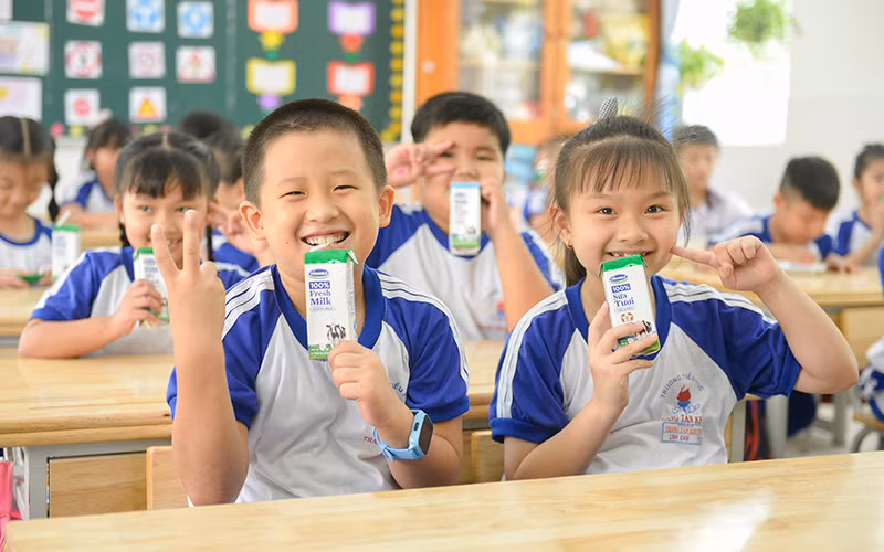 Các em học sinh trường Tiểu học Trang Tấn Khương, xã Long Thới, huyện Nhà Bè vui vẻ đón nhận những hộp sữa an toàn từ chương trình SHĐ.