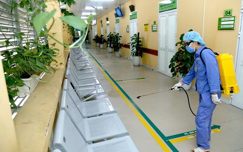 Nhân viên y tế phun khử khuẩn tại Bệnh viện Hữu nghị Việt Đức (Hà Nội).Ảnh: HÀ THU