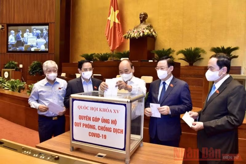 Chủ tịch nước Nguyễn Xuân Phúc, Thủ tướng Phạm Minh Chính, Chủ tịch Quốc hội Vương Đình Huệ cùng các đại biểu Quốc hội quyên góp ủng hộ Quỹ phòng chống Covid-19. Ảnh: DUY LINH