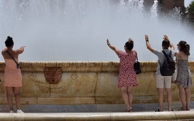 Người dân tránh nóng bên vòi phun nước tại Seville (Tây Ban Nha), ngày 10/7/2021. (Ảnh: AFP/TTXVN)