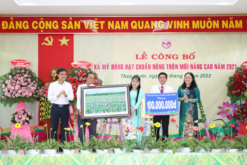 Bí thư Huyện ủy Tháp Mười Nguyễn Văn Vũ Minh, Chủ tịch UBND huyện Tháp Mười Trần Thị Quý trao quà chúc mừng xã Mỹ Đông. Công bố xã đầu tiên ở Đồng Tháp đạt chuẩn nông thôn mới nâng cao -0