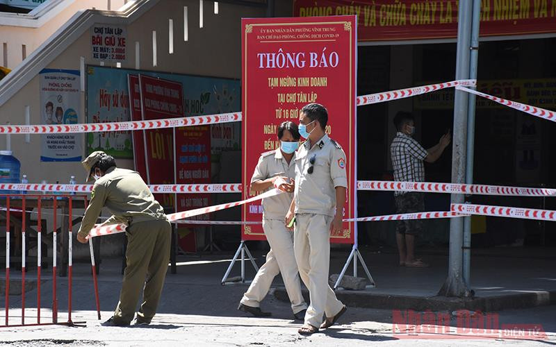 Lực lượng chức năng đặt barie chốt phong toả phía trước cổng chợ Tân Lập sáng 22-8.