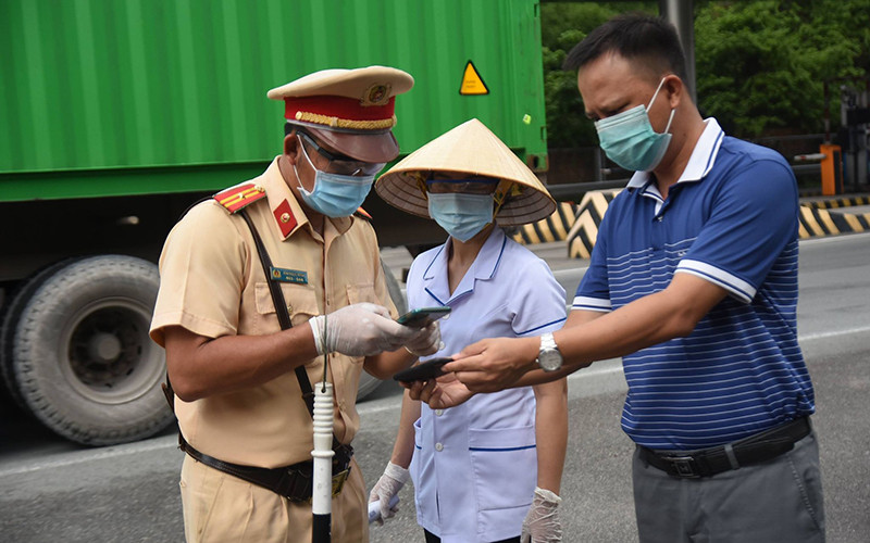 Lực lượng chức năng tỉnh Đồng Nai hướng dẫn người dân khai báo y tế. Đồng Nai nới lỏng quy định đi lại với TP Hồ Chí Minh -0