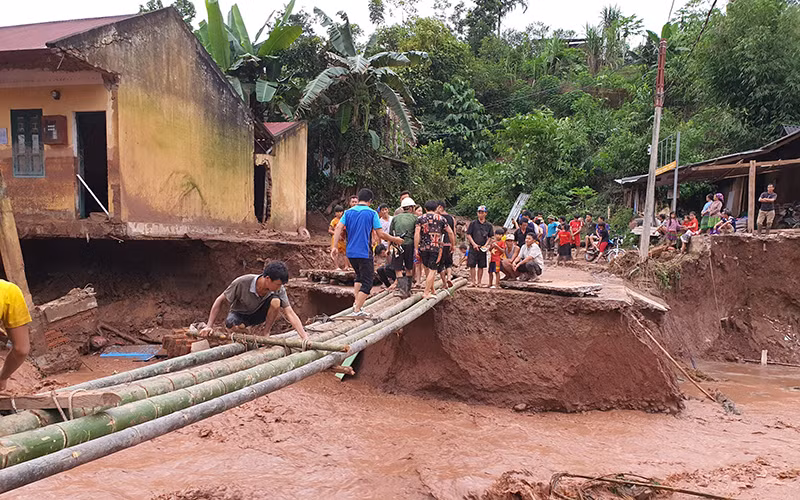 Lực lượng cứu hộ khẩn trương làm cầu tạm thay ngầm Nậm Nhừ 1 đã bị lũ cuốn trôi.