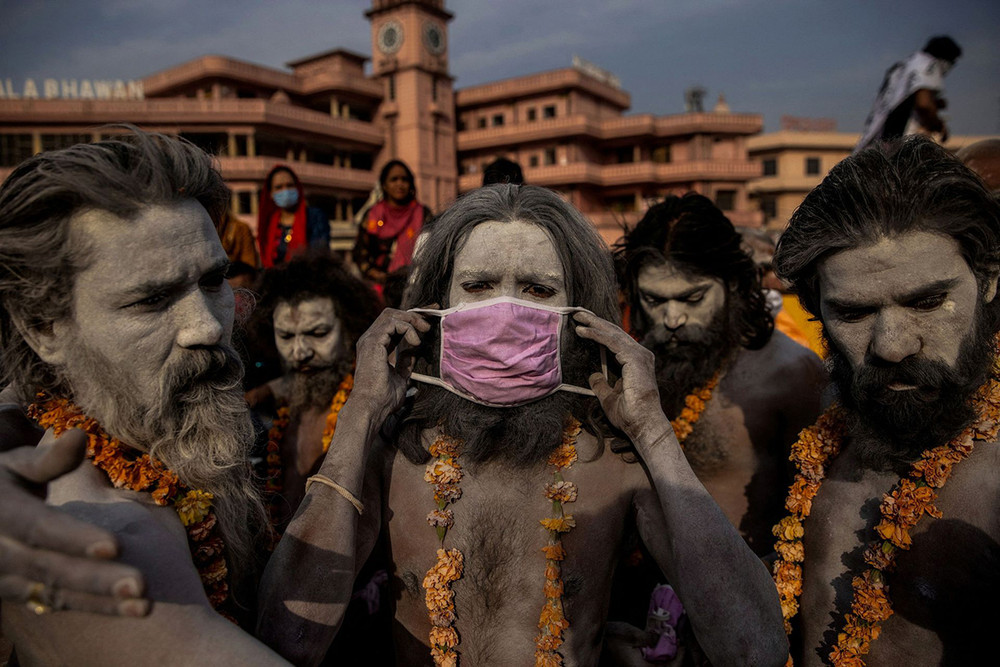 Một Naga Sadhu - tu sĩ khổ hạnh theo đạo Hindu - đeo khẩu trang trước khi ngâm mình trên sông Hằng trong lễ Kumbh Mela tại TP Haridwar, ngày 12/4/2021. Số ca mắc và tử vong do Covid-19 đã tăng mạnh tại Ấn Độ trong tháng 4 và 5/2021. Trong thời gian cao điểm của đại dịch, nhiều bệnh viện tại nước này đã bị thiếu oxy y tế, khiến nhiều bệnh nhân tử vong. (Ảnh: REUTERS/Danish Siddiqui) Loạt ảnh về đại dịch Covid-19 tại Ấn Độ của Reuters giành giải Pulitzer 2022 -0