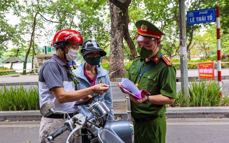 Lực lượng chức năng kiểm tra các phương tiện lưu thông trong thời gian giãn cách xã hội. (Ảnh: TTXVN)