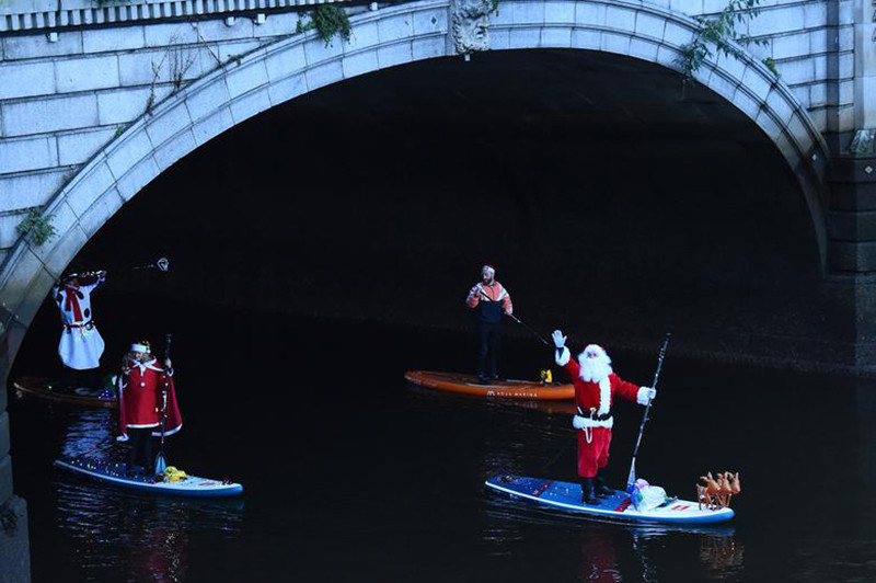 Hóa trang thành ông già Noel và dùng ván lướt sóng di chuyển trên sông Liffey, thành phố Dublin, Ireland, để mang đến niềm vui Giáng sinh trong không khí ảm đạm của đại dịch Covid-19. Noel -0