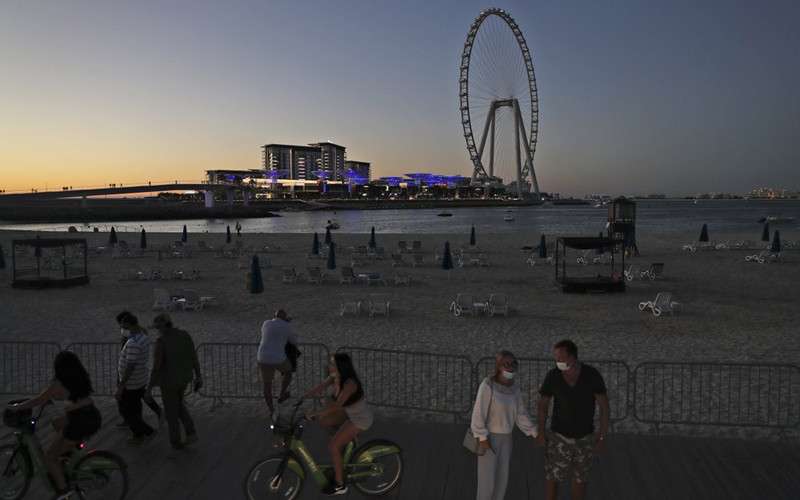 Du khách và người dân thưởng thức hoàng hôn ở bãi biển Jumeirah, Dubai (Ảnh: AP) Dubai hút khách nước ngoài dù Covid-19 gia tăng -0
