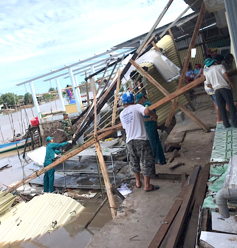 Lực lượng chức năng giúp dân thu dọn đống đổ nát sau vụ sạt lở khu vực chợ Kênh 17. Sạt lở nhấn chìm 14 nhà dân miệt sông nước Cà Mau -0