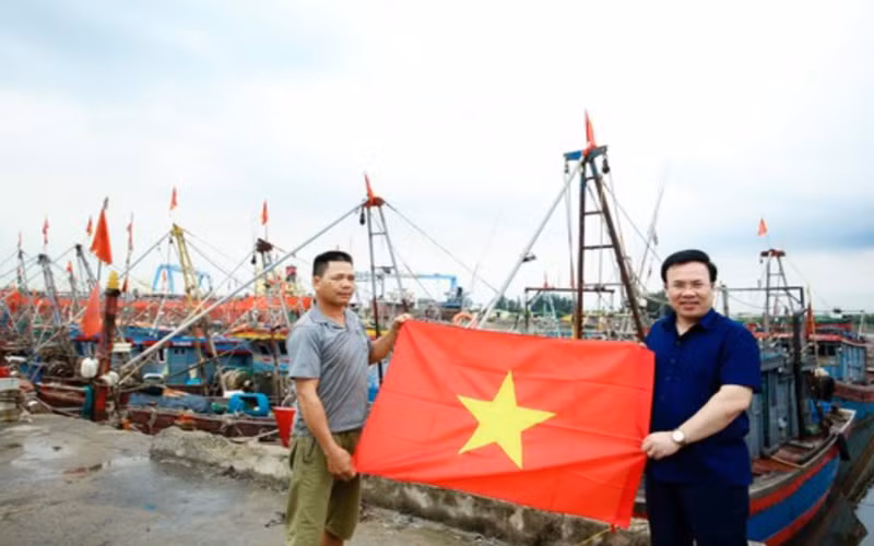 Ngư dân Nguyễn Văn Hà, trú tại đội 1, thị trấn Diêm Điền (huyện Thái Thụy, tỉnh Thái Bình) nhận cờ Tổ quốc tại cảng cá Diêm Điền.