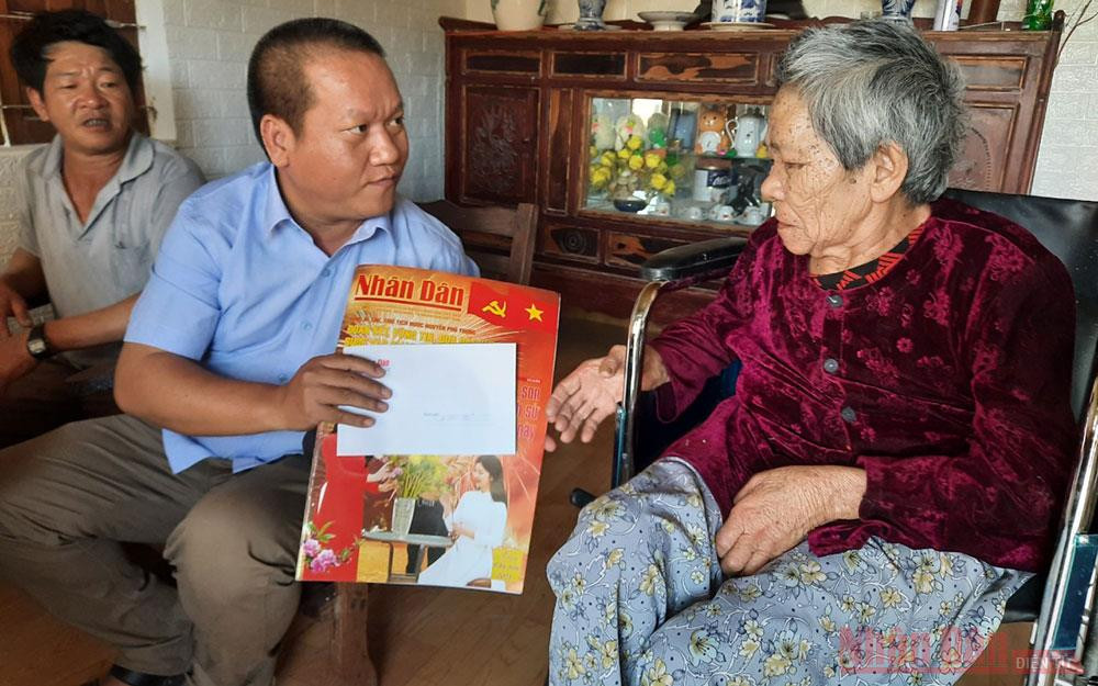 Phóng viên Báo Nhân Dân tặng suất quà Tết cho bà Nguyễn Thị Ký là hộ nghèo, neo đơn, nằm liệt một chỗ. Báo Nhân Dân trao tặng quà dịp Tết Nguyên đán 2021 tại Kon Tum -0