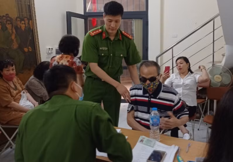 Đội Cảnh sát QLHC về TTXH Công an quận Ba Đình hỗ trợ ông Đinh Phương Thi là thương binh hỏng mắt, làm thủ tục cấp CCCD mới.