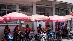 Ảnh minh họa: Các lái xe máy chở khách tránh nắng nóng tại Bangkok, Thái Lan. (Ảnh: THX/TTXVN)